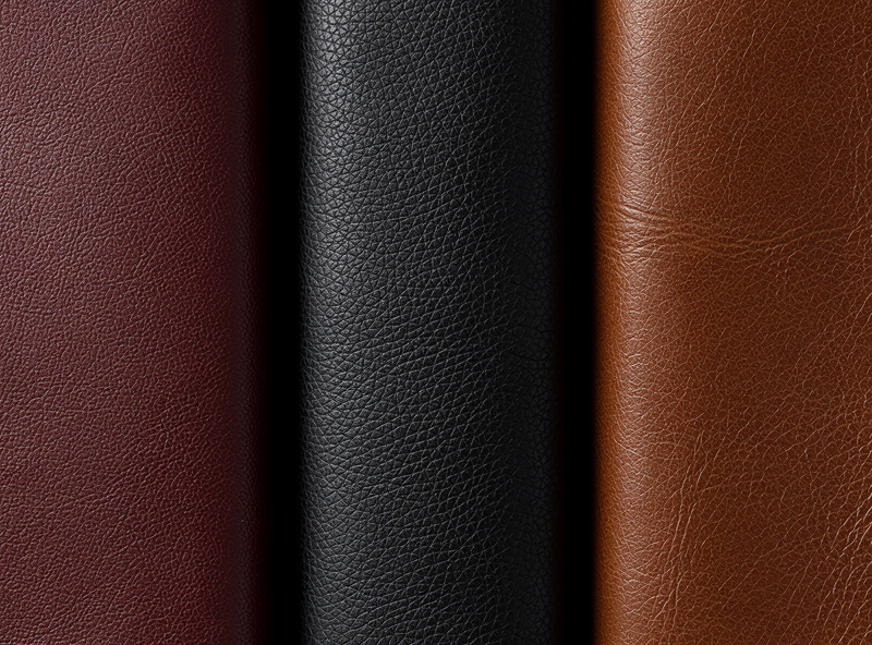 Macro view of three finished leather pieces side by side showing successful uniform dye jobs — left a deep mahogany red, middle a true black, right a warm cognac brown all with consistent depth and saturation