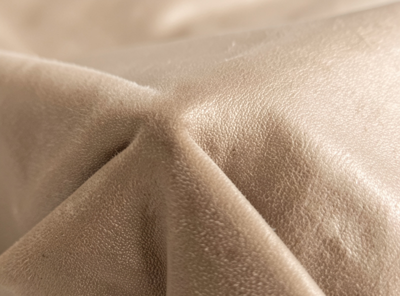 A soft chrome-tan leather edge being slicked, showing it staying matte rather than glossing like veg-tan