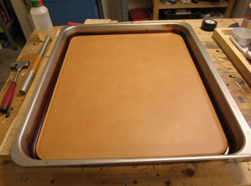 A molded veg-tan leather panel being heat-set in a low oven to harden it
