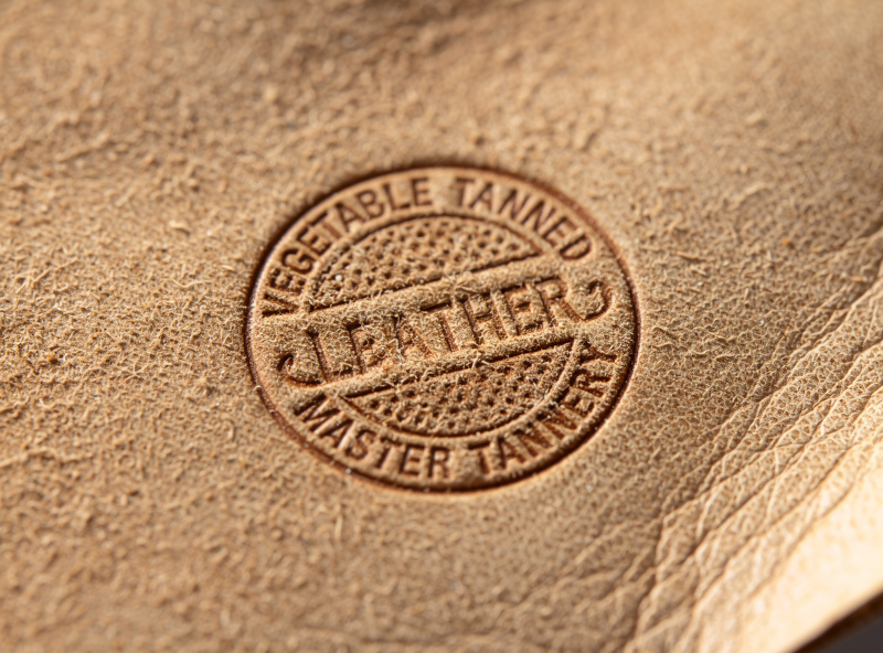 Close-up of a vegetable-tanned leather hide with a stamped certification mark