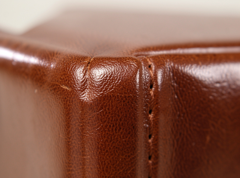 Close-up of a slicked and waxed leather book spine showing tight even stitching