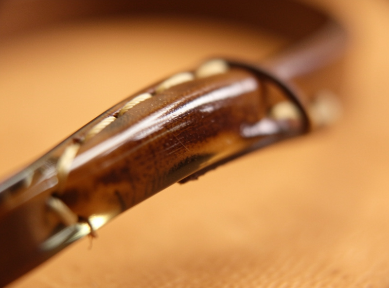 Close-up of the burnished glassy edge and handle loop of a finished leather dog leash