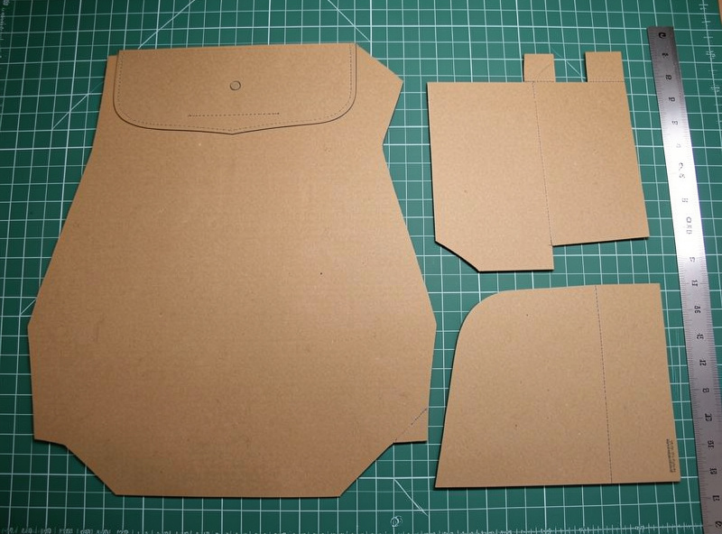 Leather messenger bag pattern pieces in cardstock laid out with body, flap, and gusset templates
