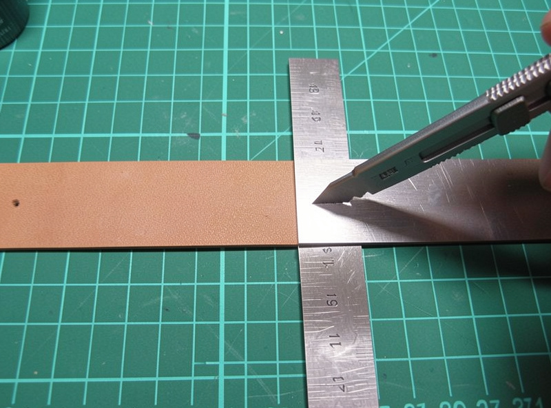 Strip of 9 oz veg-tan leather cut to belt width on a self-healing mat with a steel straightedge