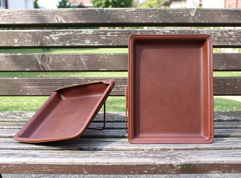 A collapsed thin-leather tray slumping next to a crisp thick-leather tray standing square