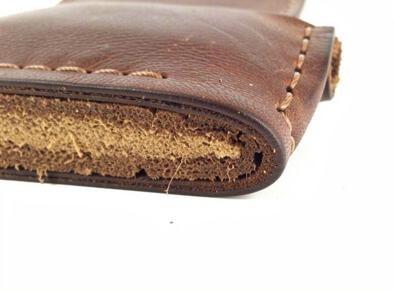Cross-section of a built-up padded leather strap showing layered core, padding, and stitched outer wrap