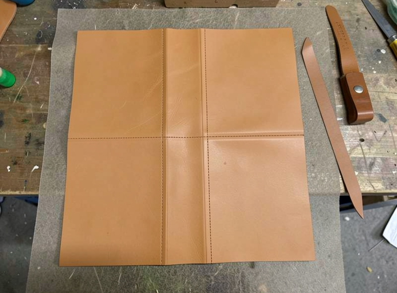 Flat unfolded veg-tan leather key case pattern with crease lines marked