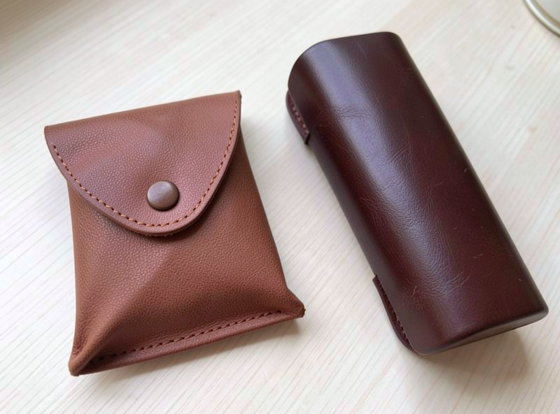 Soft folded leather sunglasses pouch next to a rigid hard leather case