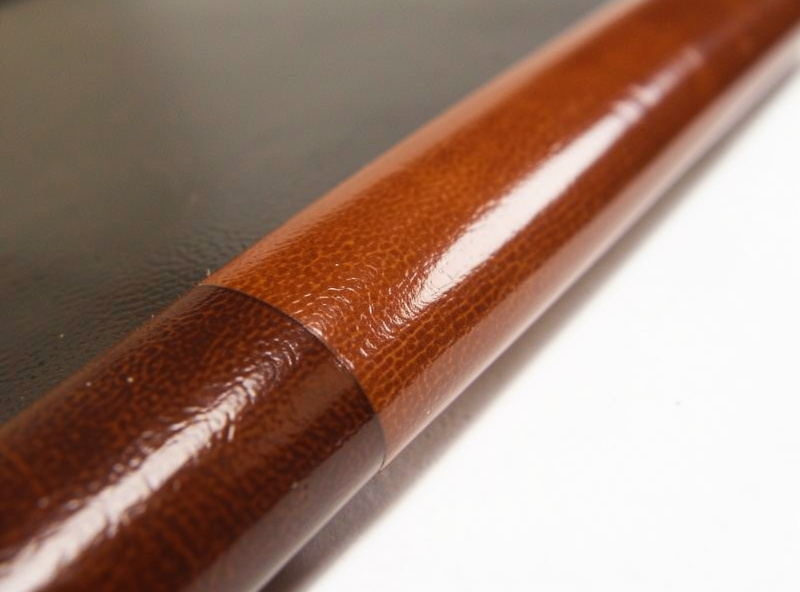 A burnished leather edge being slicked with a printed edge slicker