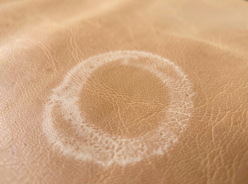 A water tide line drying on the surface of tan veg-tan leather