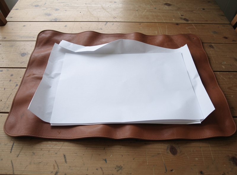 Leather bag panel laid flat to air dry away from heat after water stain treatment